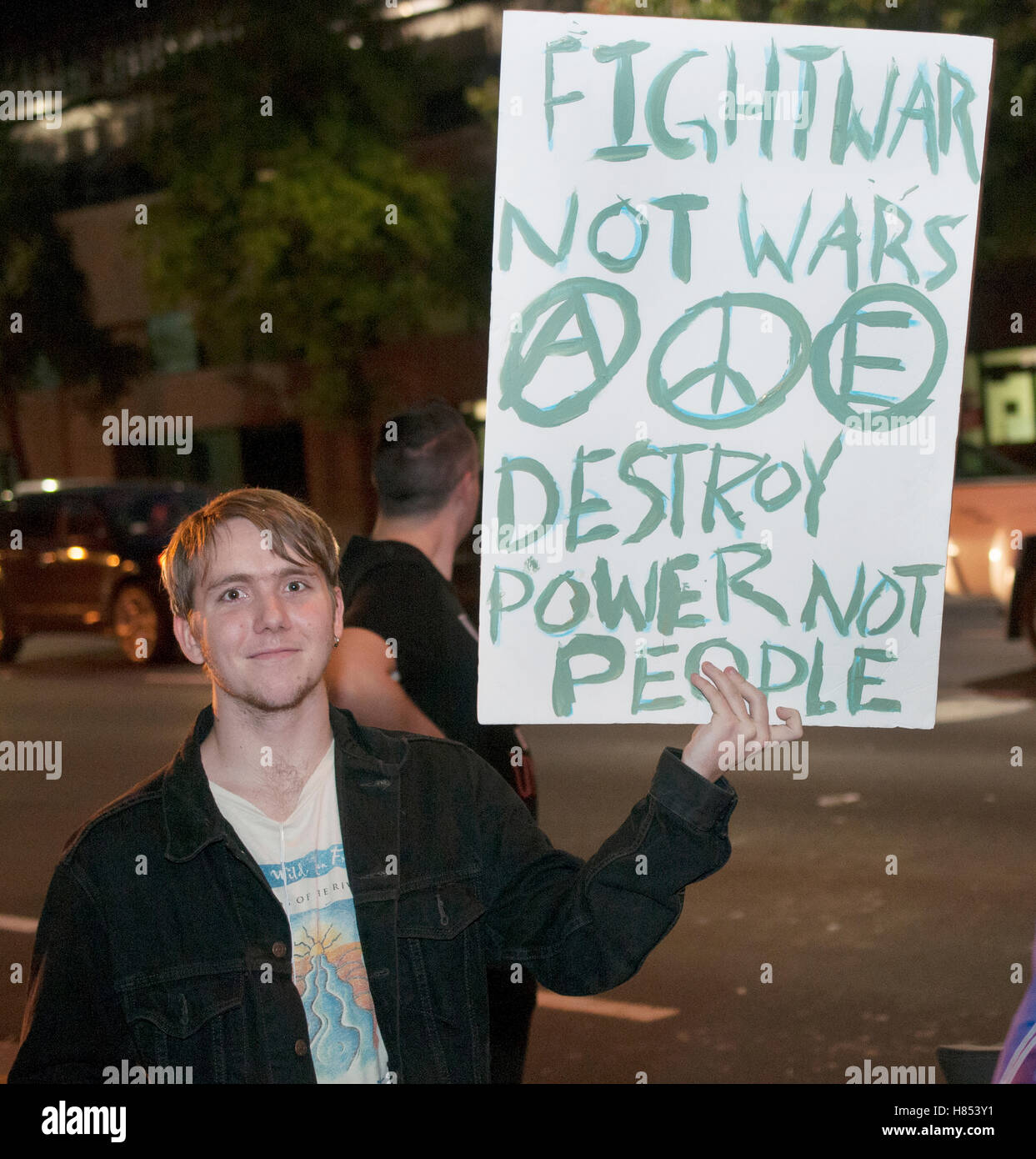 An activist holds a sign reading “fight not wars Destroy power now people” at a protest against the 2016 election results. Credit:  Alex Arnold/Alamy Live News Stock Photo