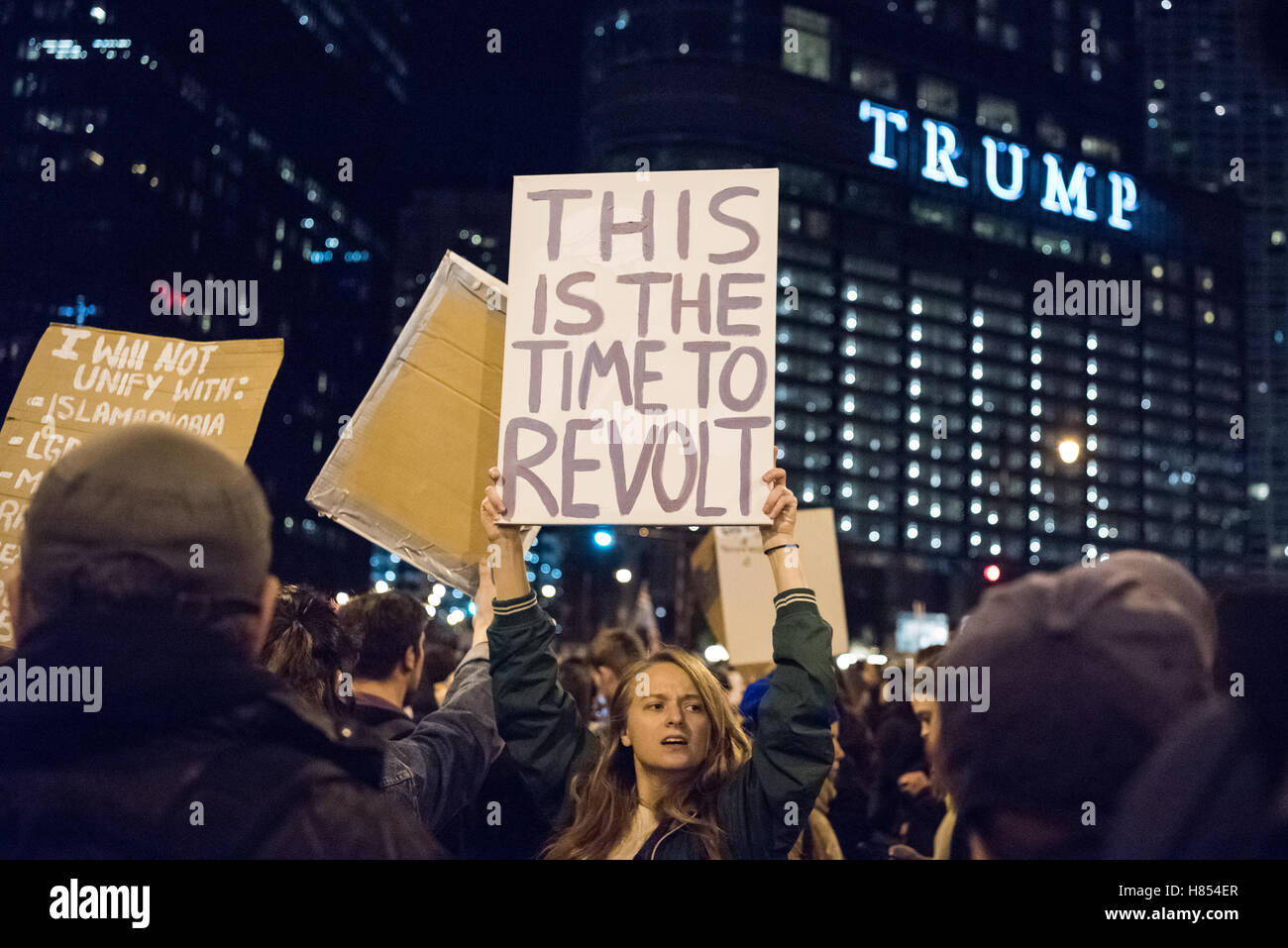 Chicago, Illinois, USA. 9th November, 2016. A protestor holds a sign reading 'This is the time to revolt' in front of Trump tower in a anti-trump protest. Credit:  Caleb Hughes/Alamy Live News. Stock Photo