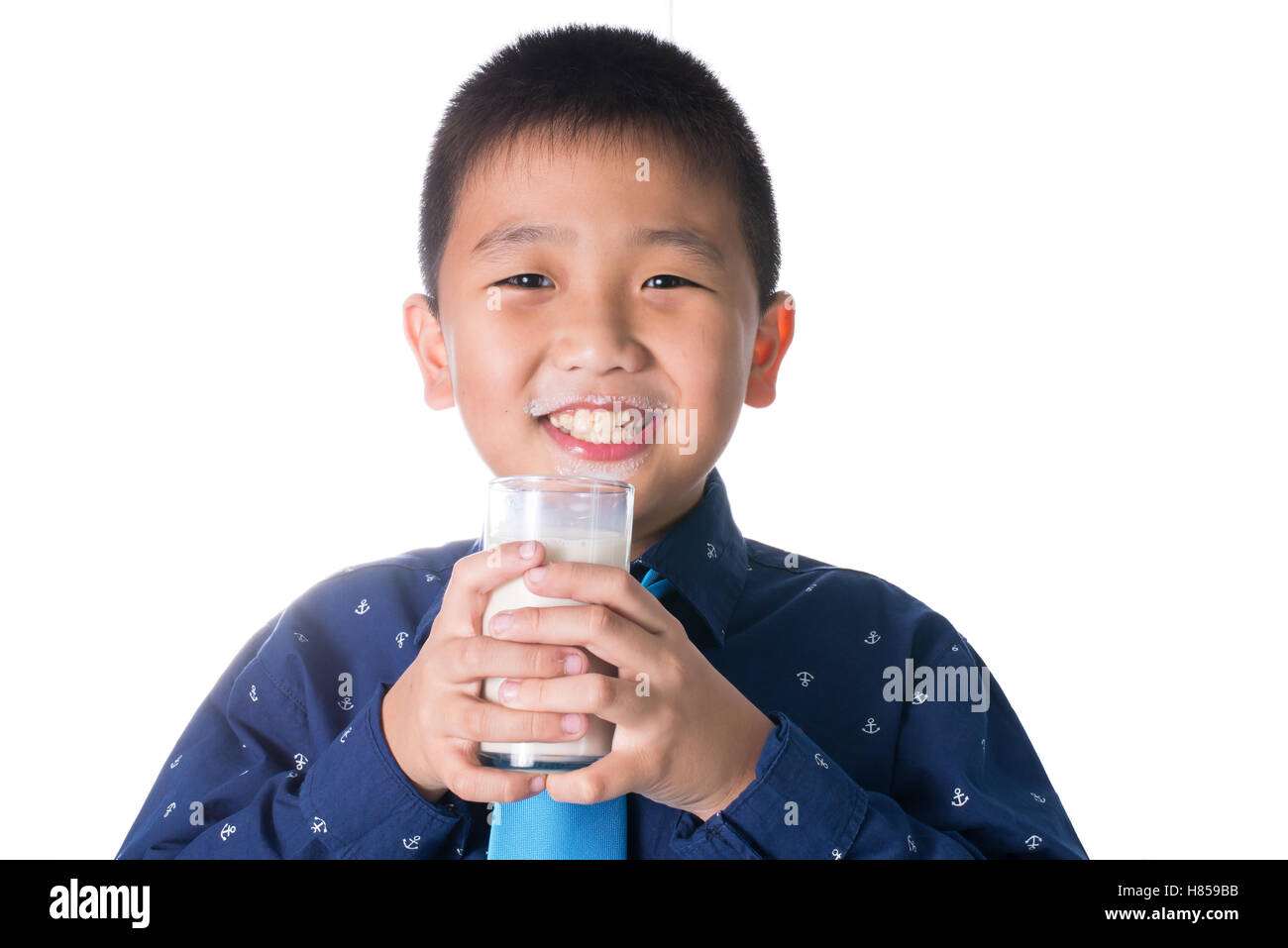 Boy drinking milk with milk mustache holding glass of milk isolated on