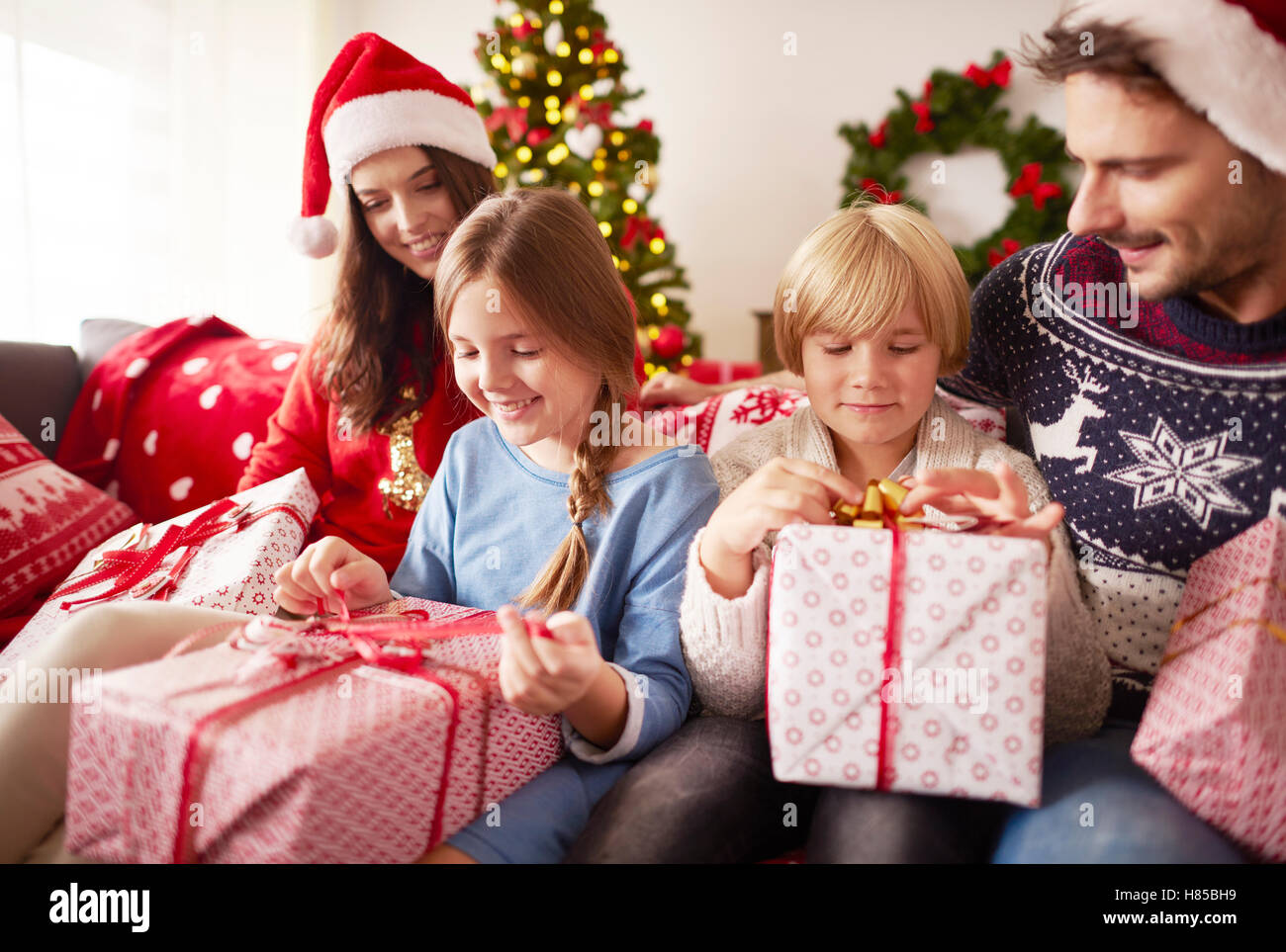 Kids start opening Christmas presents Stock Photo Alamy
