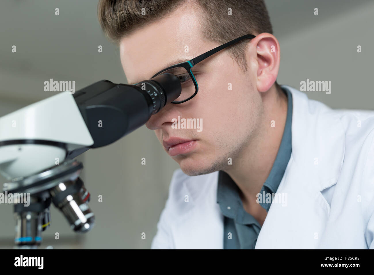 Scientist looking through a microscope in a laboratory Stock Photo - Alamy