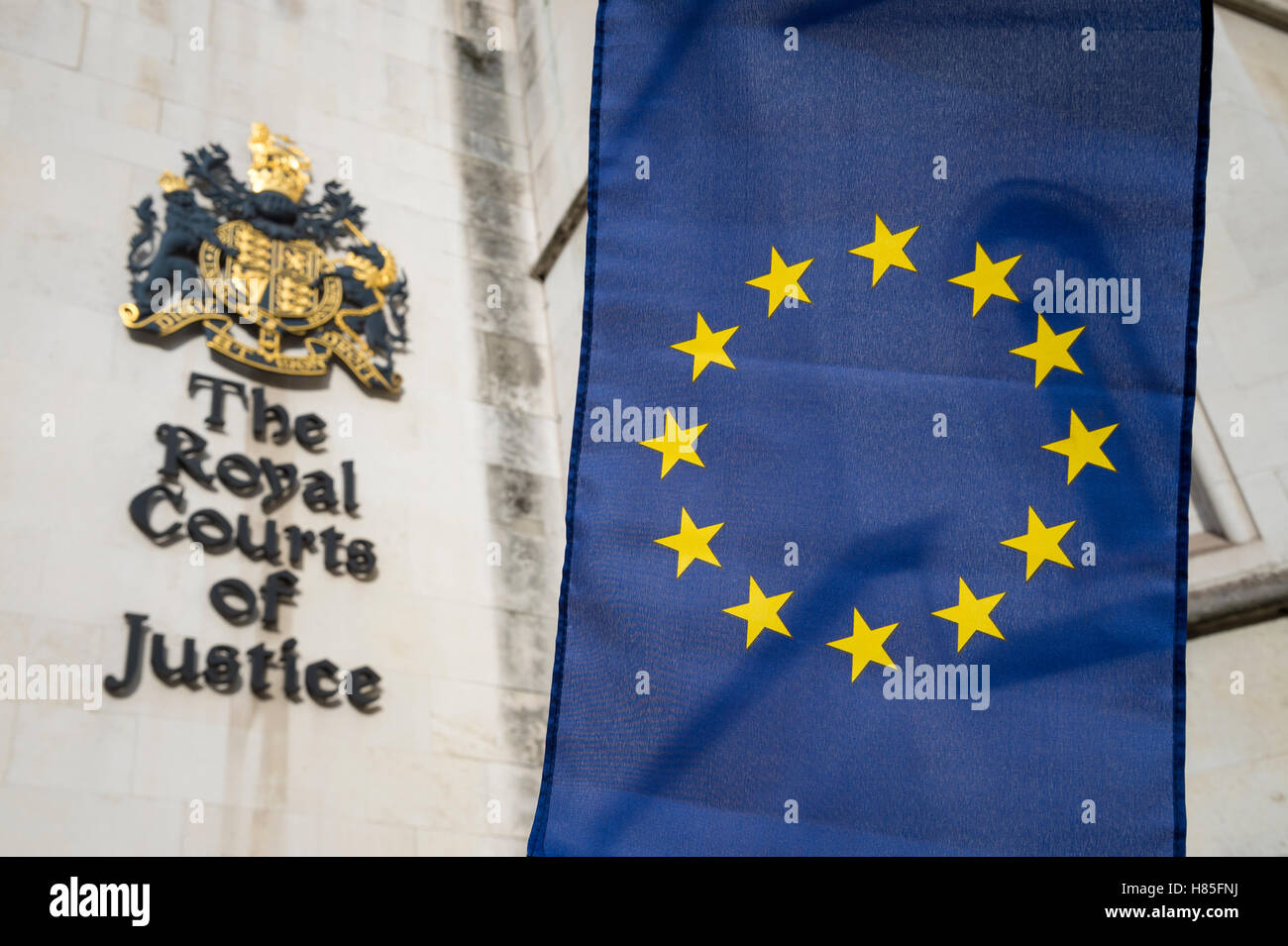 European Union flag flying in front of The Royal Courts of Justice public building in London, UK Stock Photo