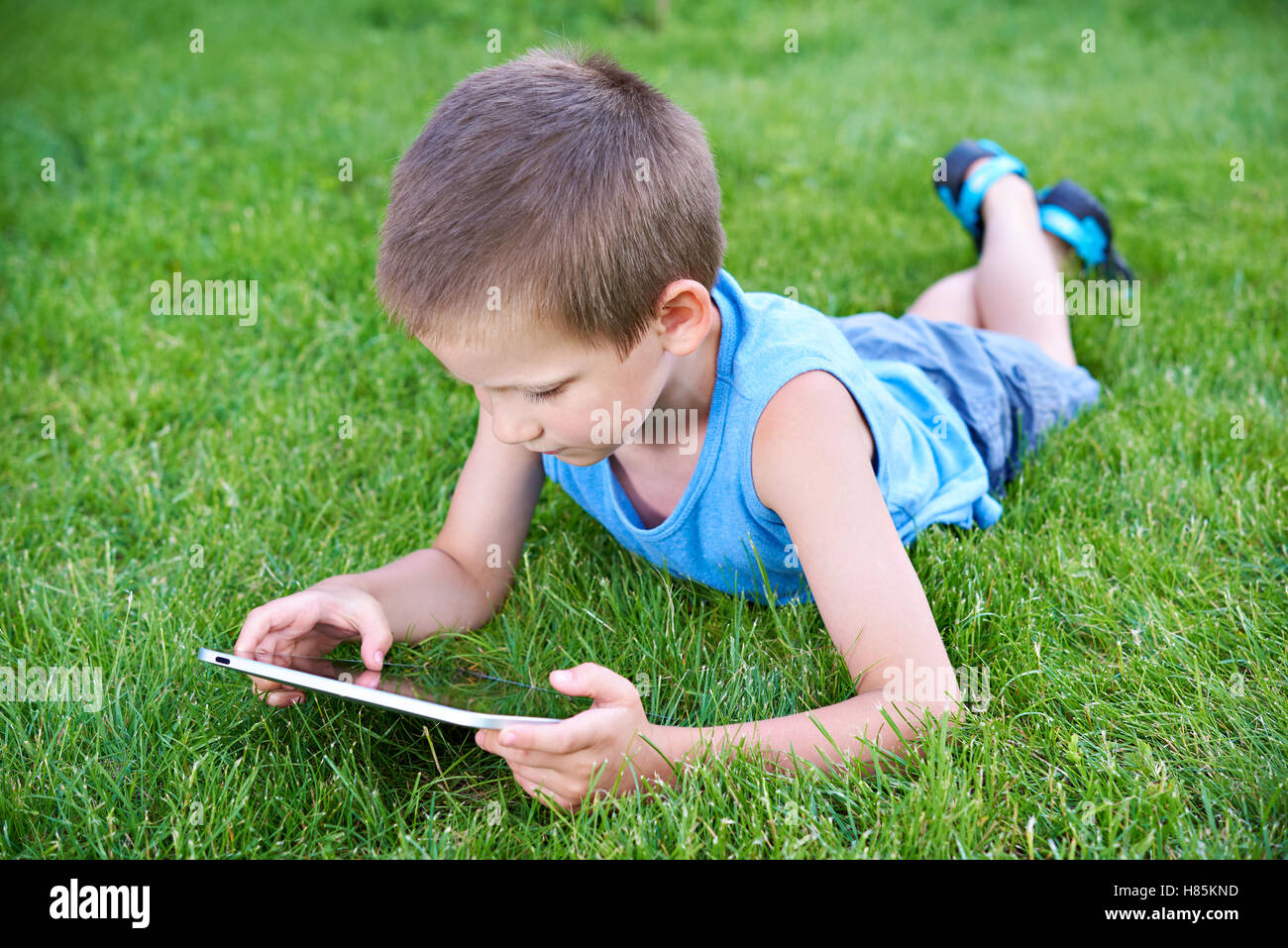 Little boy with tablet pc in summer day Stock Photo - Alamy