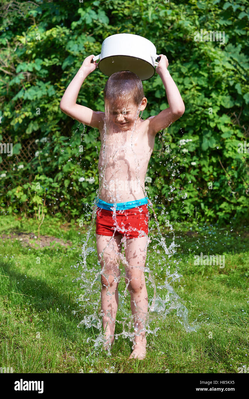 Little boy pouring water over in summer day Stock Photo - Alamy