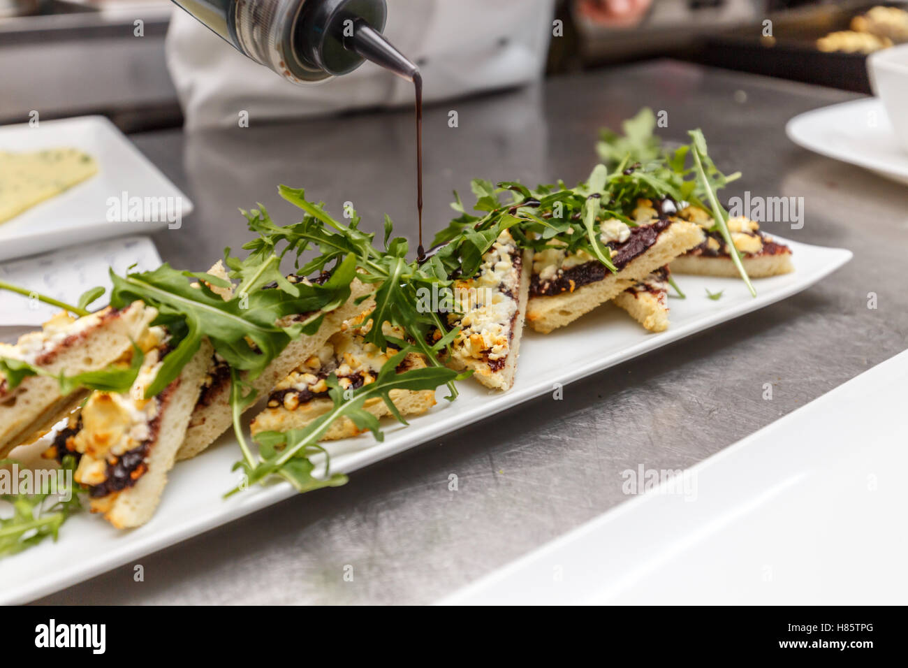 Chef decorating appetizer dish in restaurant kitchen Stock Photo Alamy