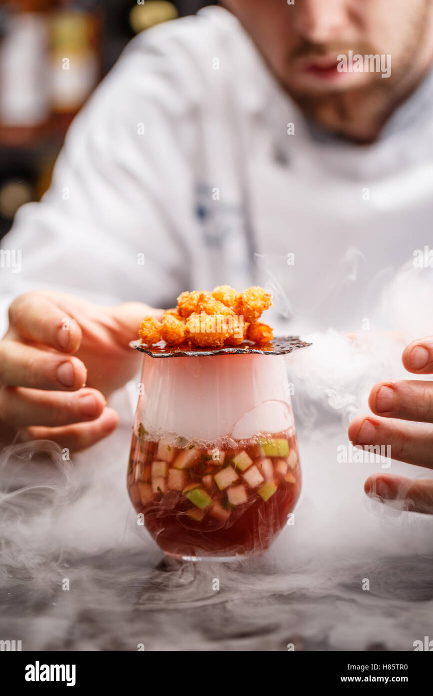 Fruit soup with dry ice, Chef decorating Stock Photo
