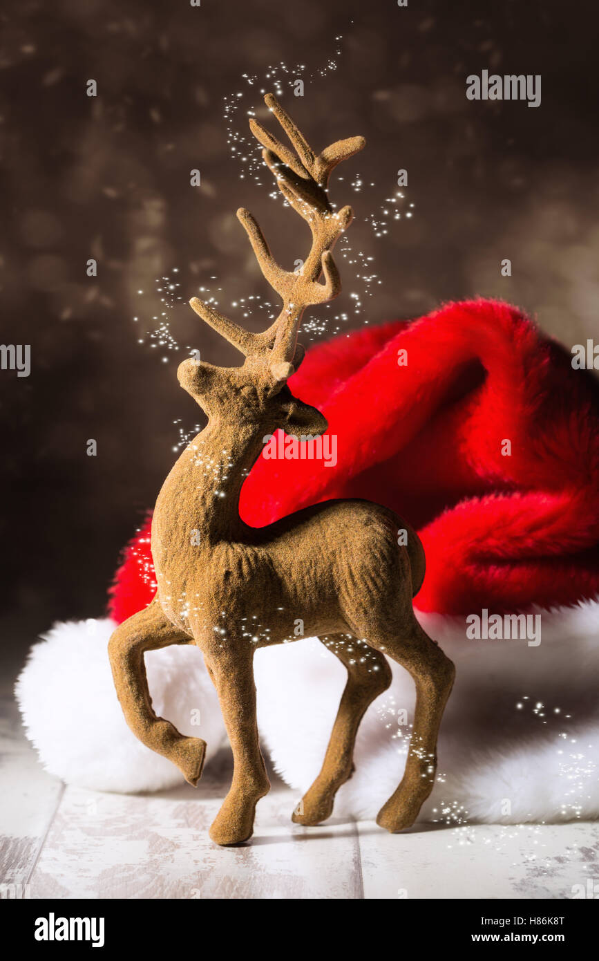 Christmas reindeer with santa hat in festive setting Stock Photo