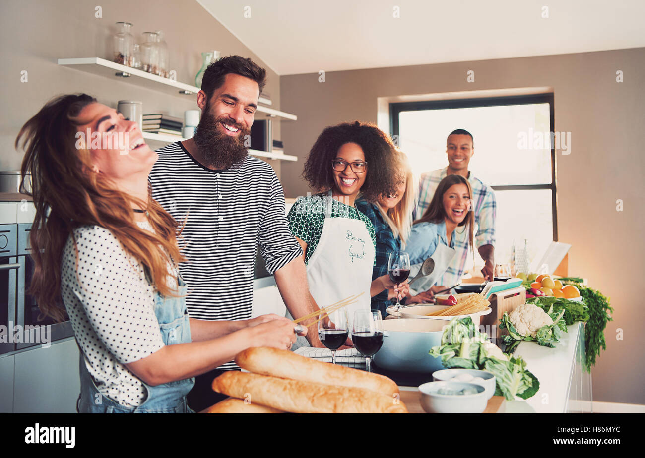 Group of foodies preparing a meal together in kitchen at school or home ...