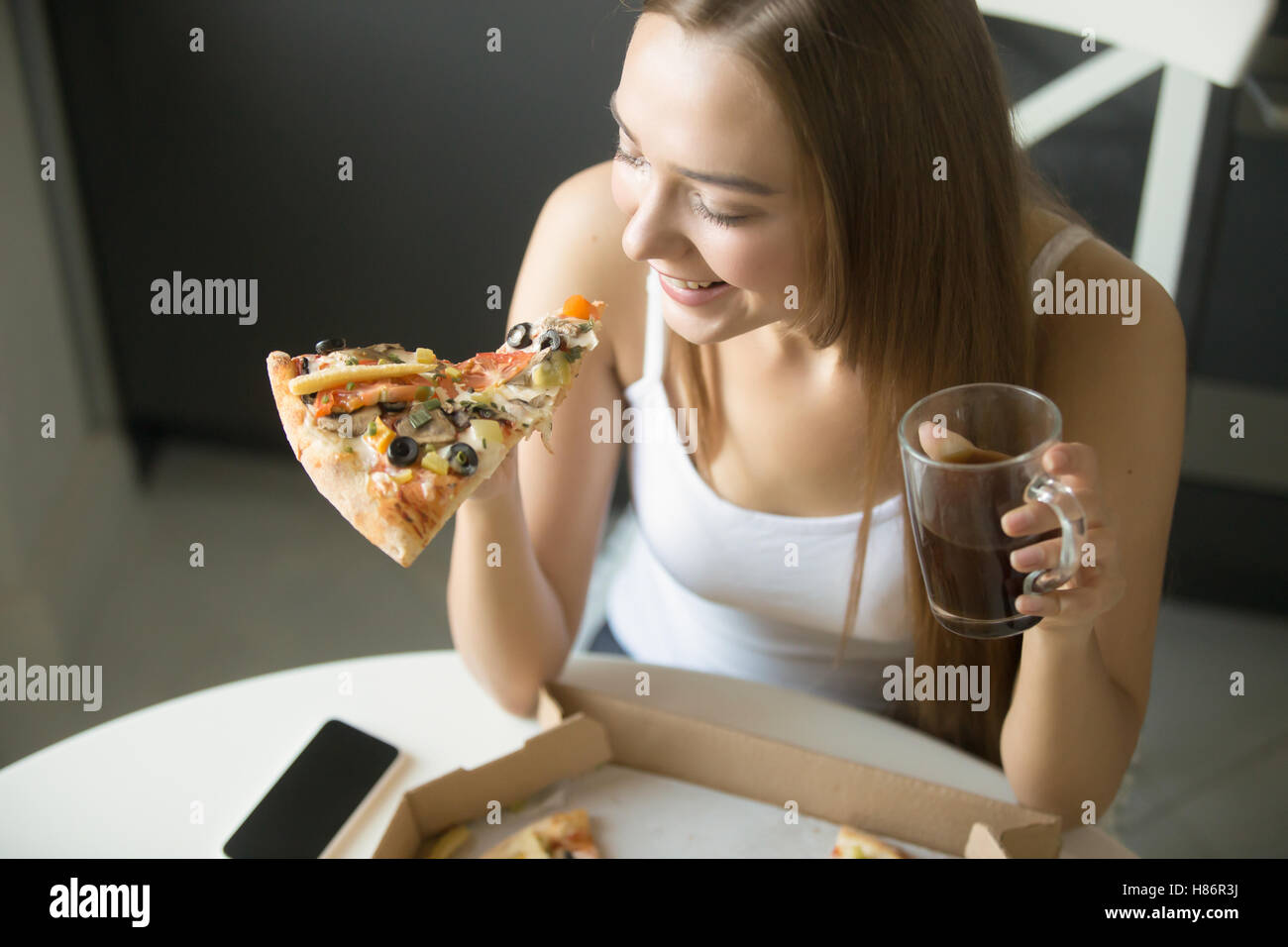 Young smiling girl with a slice of pizza Stock Photo