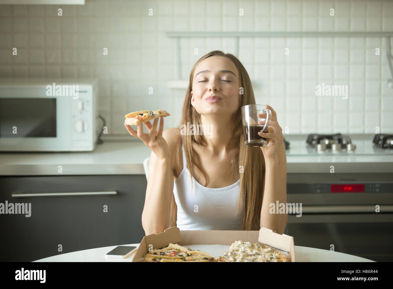 Portrait of a smiling woman with pizza in her hand Stock Photo