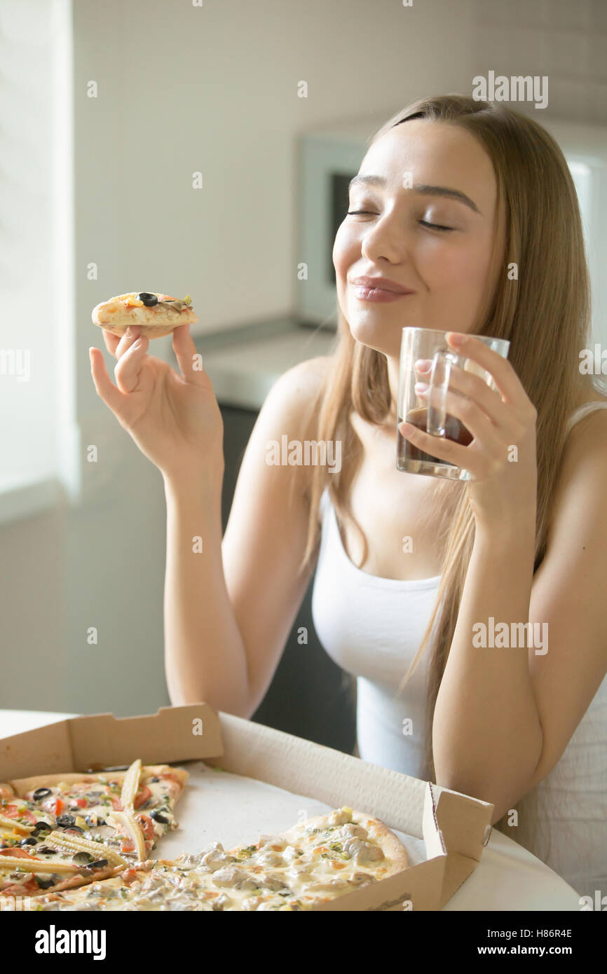 Portrait of a young woman with pizza in her hand Stock Photo
