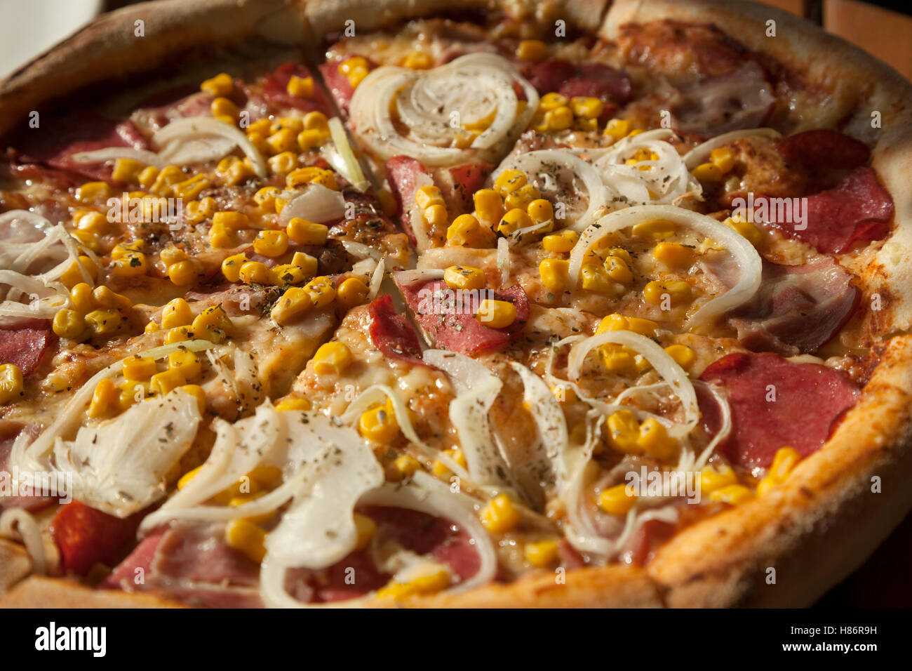 big pizza with meat and vegetables on table Stock Photo
