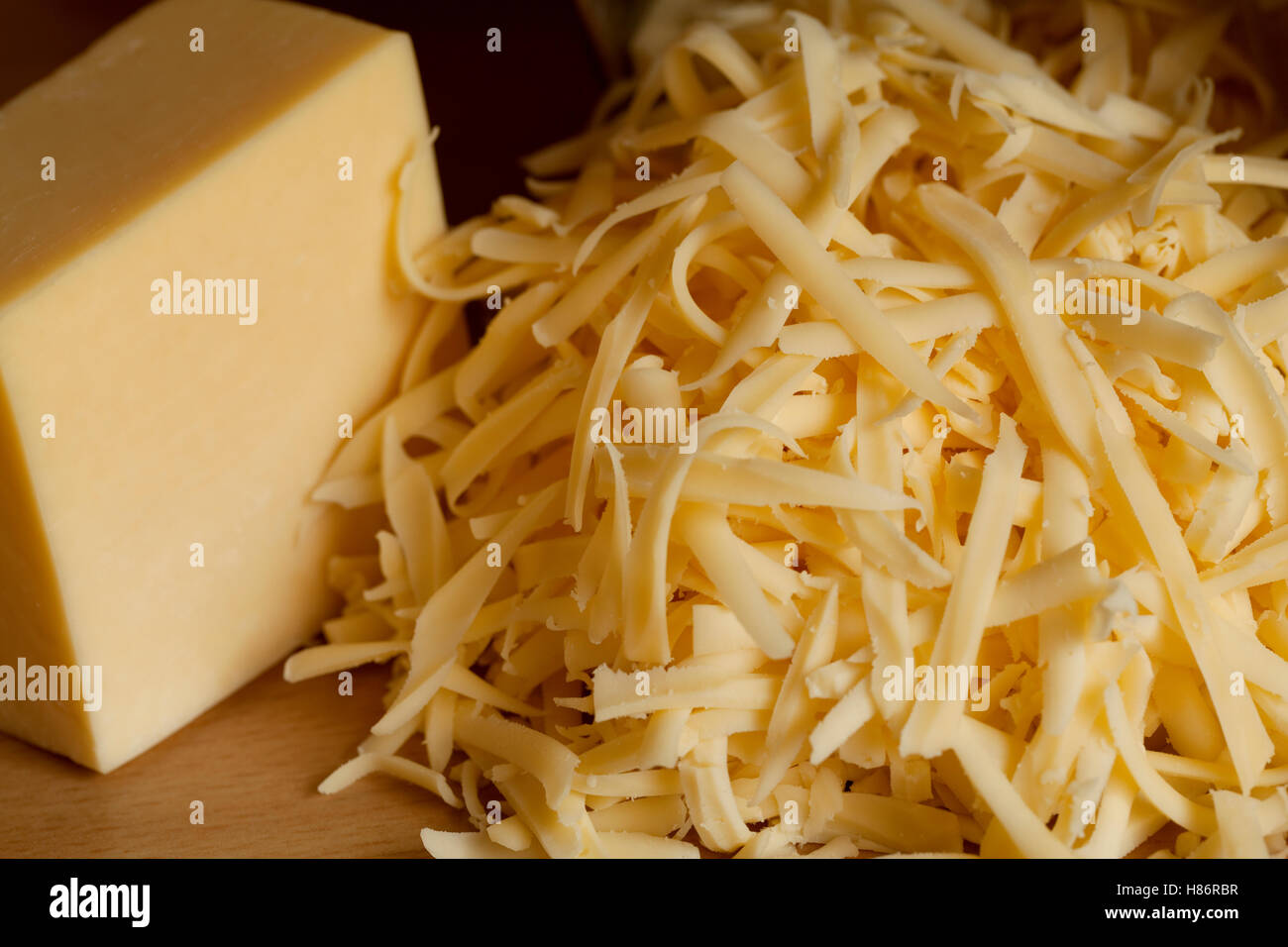 ankle of yellow and grated cheese on plank Stock Photo