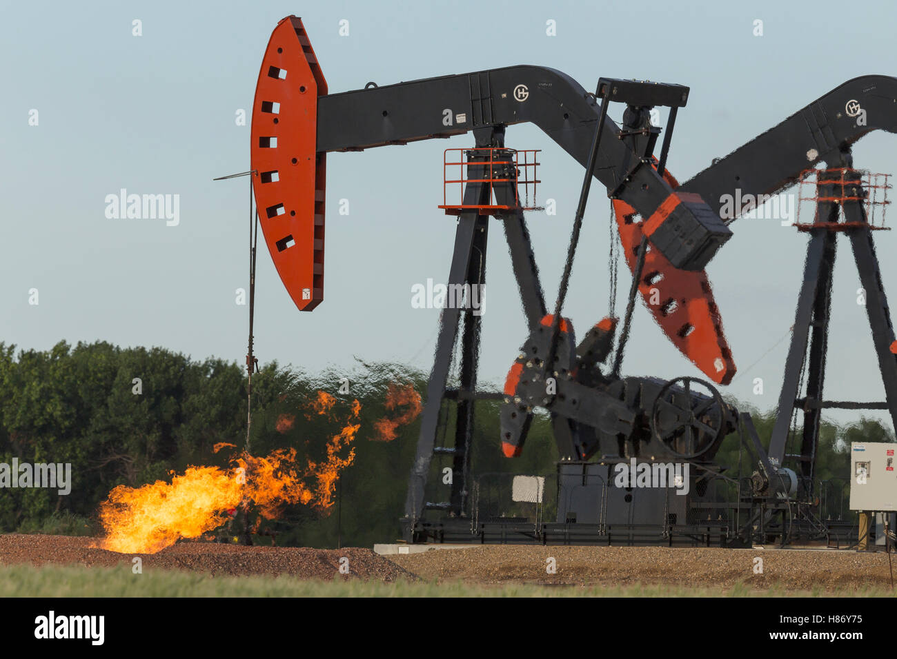 Pumpjacks working with flames flaring from excess natural gas, Williston Basin, North Dakota Stock Photo