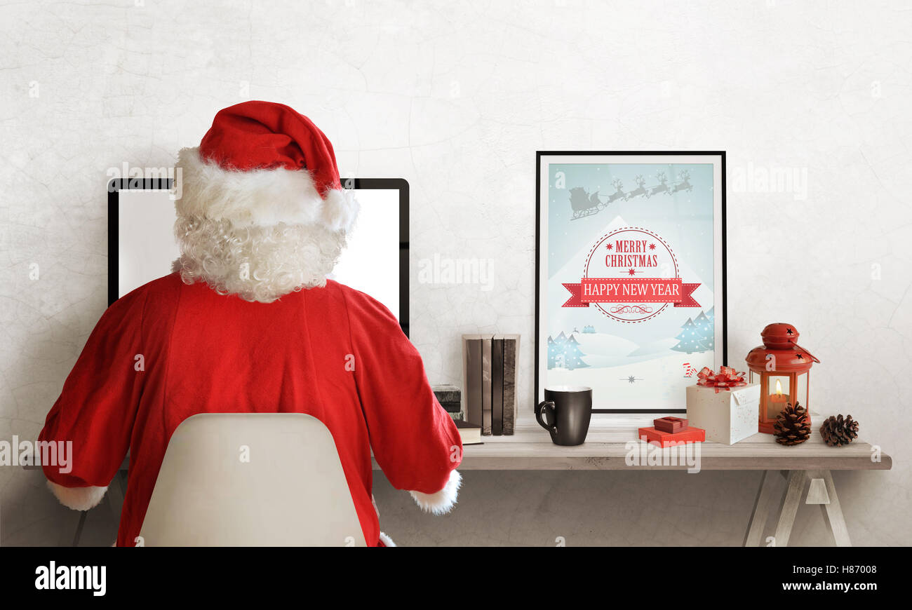 Santa Claus planning trip on computer. Gifts, books, tea, picture and lantern on table. Stock Photo