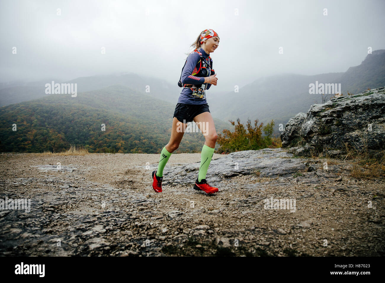 young girl runner running in rain in compression socks and running backpack  during Crimea mountain marathon Stock Photo - Alamy