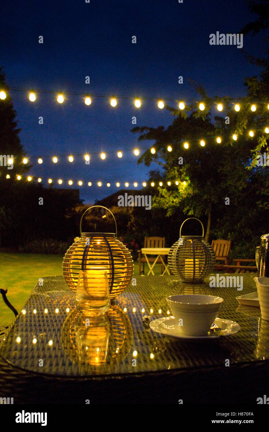 Late summer evening in an English garden with decorative lights Stock Photo