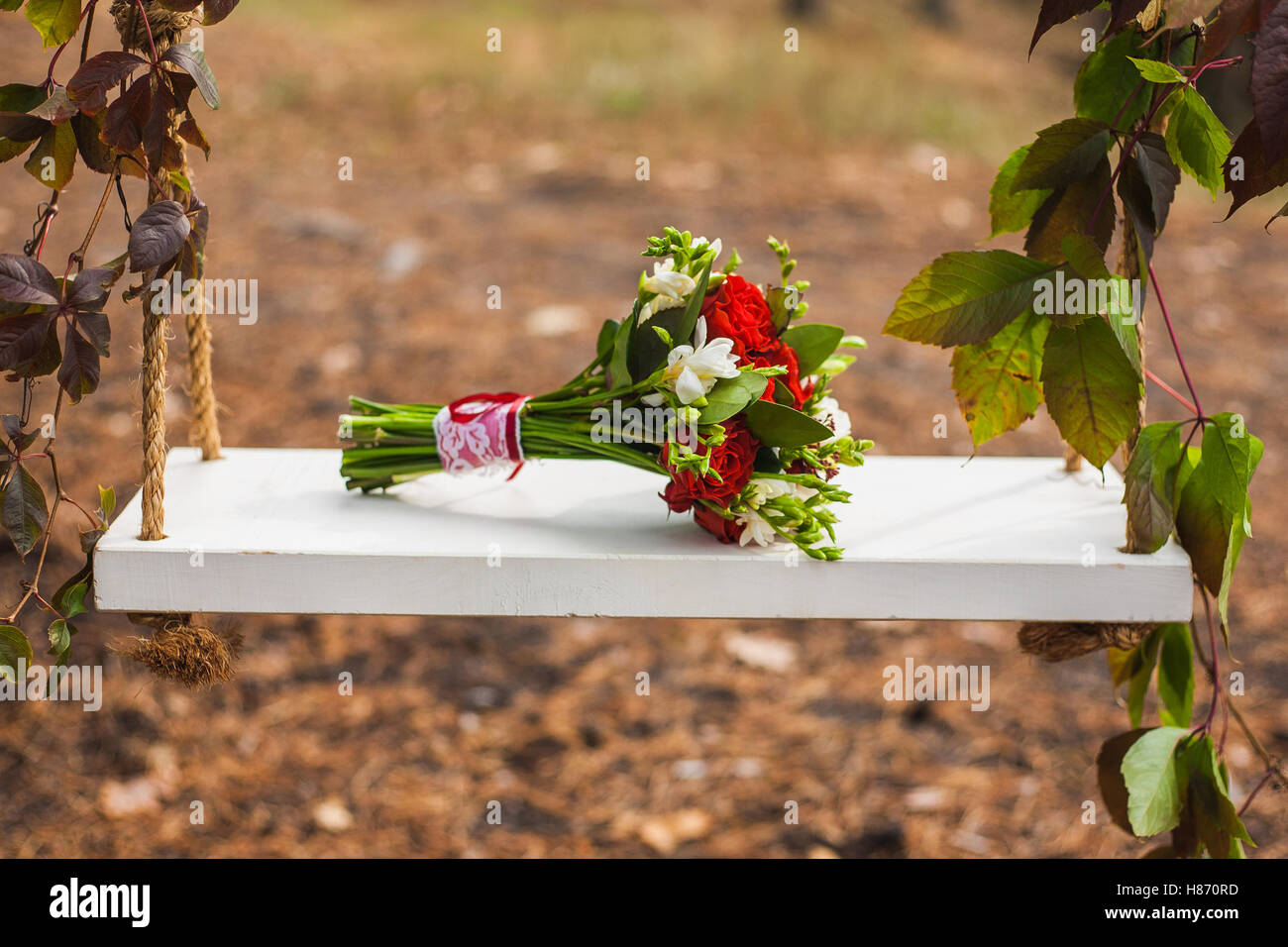 Beautiful swing, decorated ivy with bouquet Stock Photo