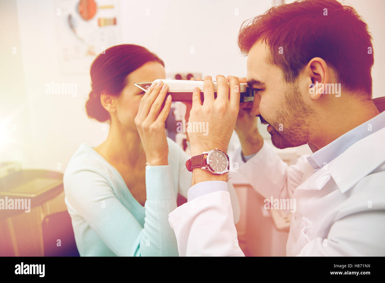 optician with pupilometer and patient at eye clinic Stock Photo