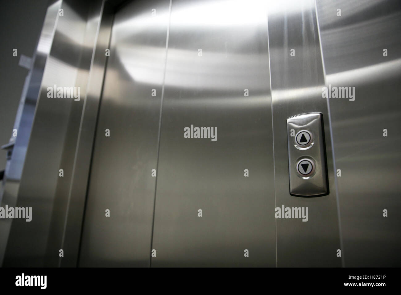 elevator or lift closed metal doors and buttons Stock Photo