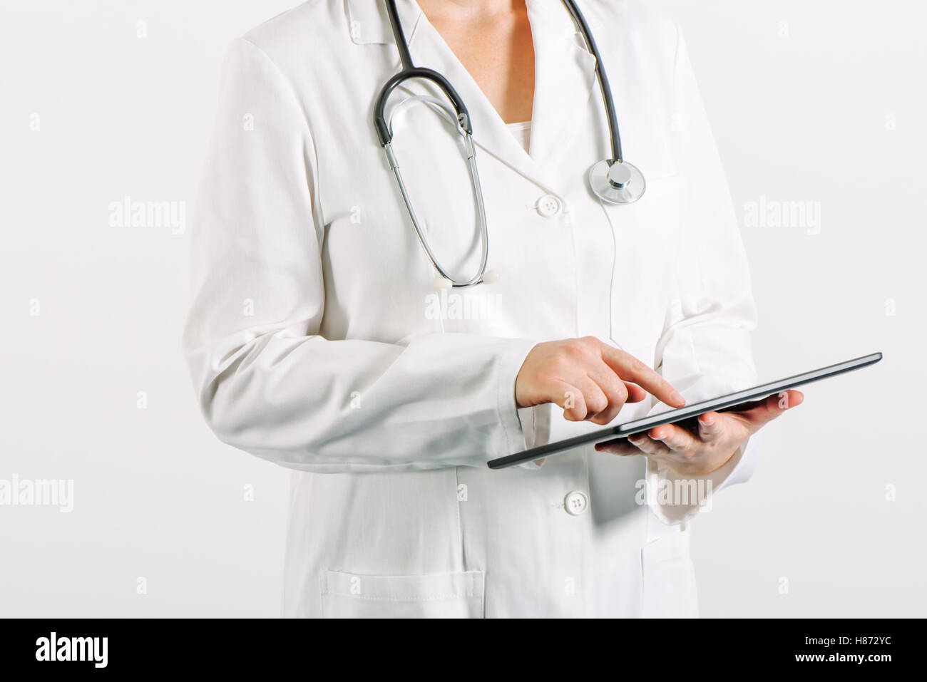 Female general medical practitioner using tablet computer in hospital office Stock Photo