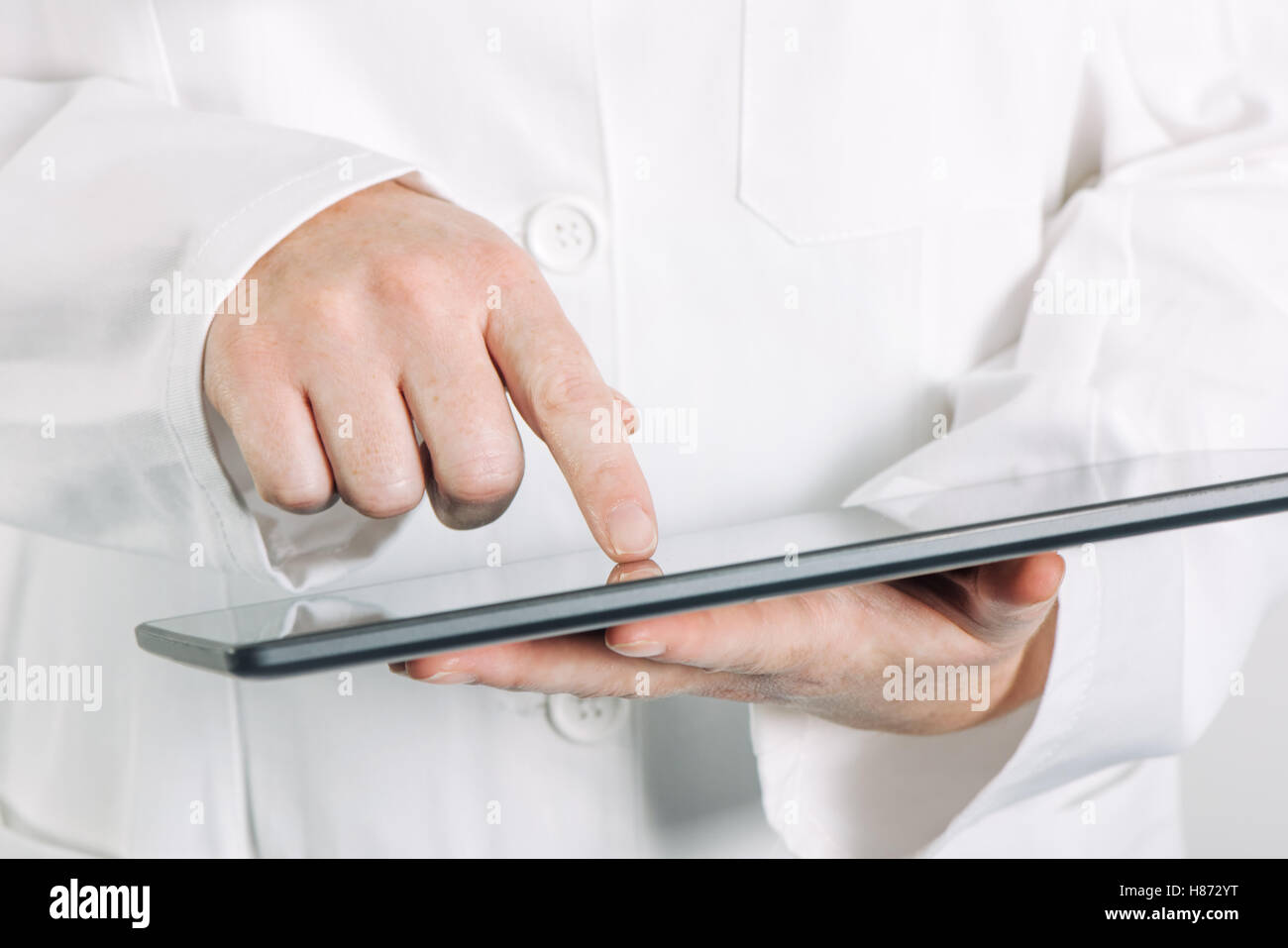 Female general medical practitioner using tablet computer in hospital office Stock Photo