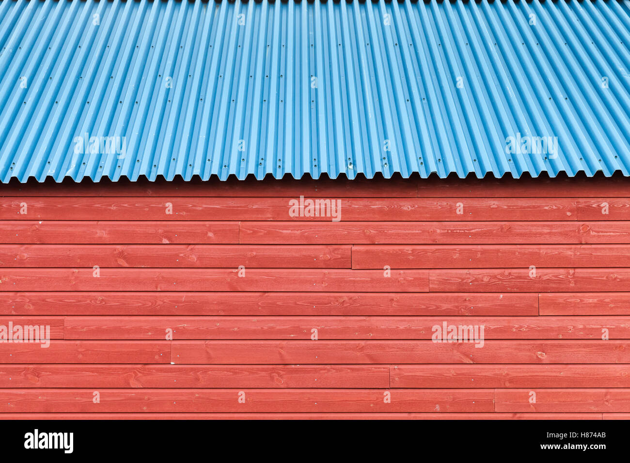 Red wooden wall under blue metal roof, background photo texture Stock Photo
