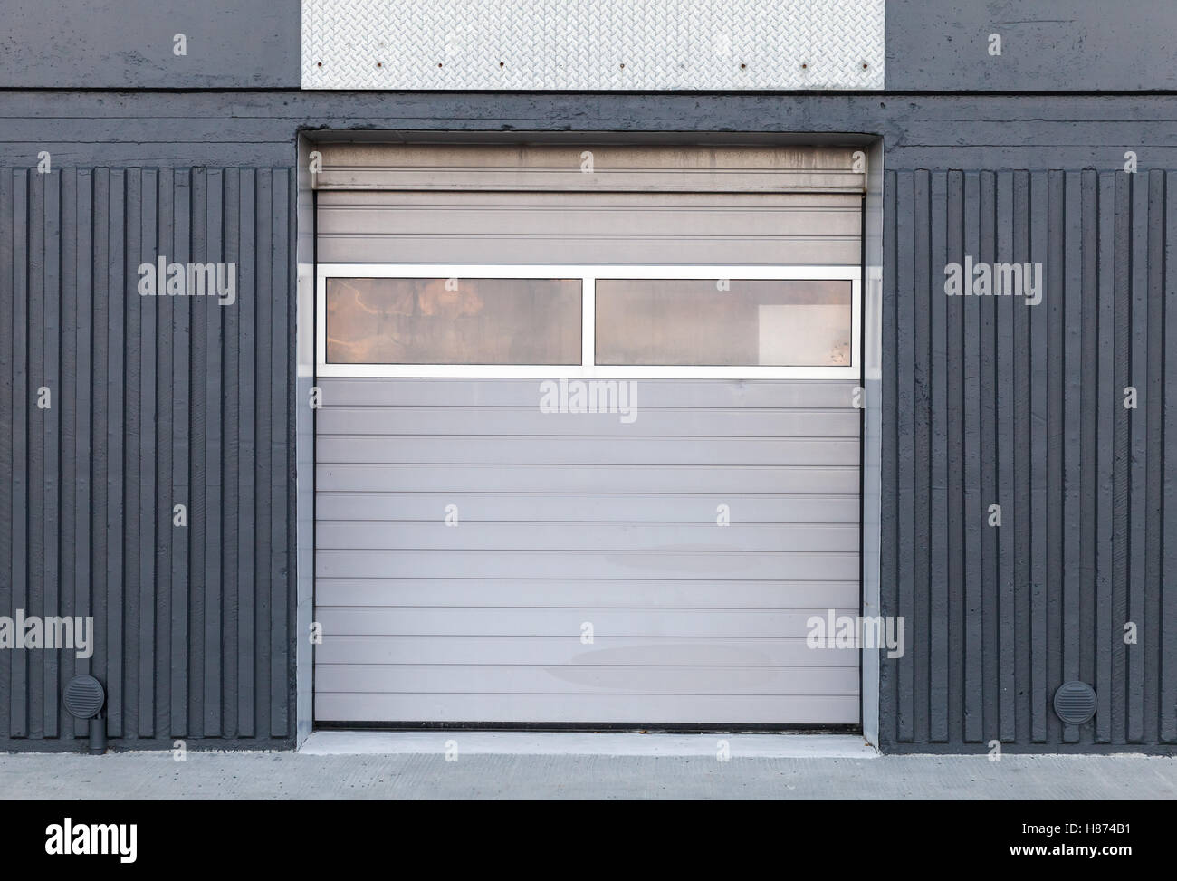 Closed gate in gray metal warehouse wall, flat background photo texture Stock Photo