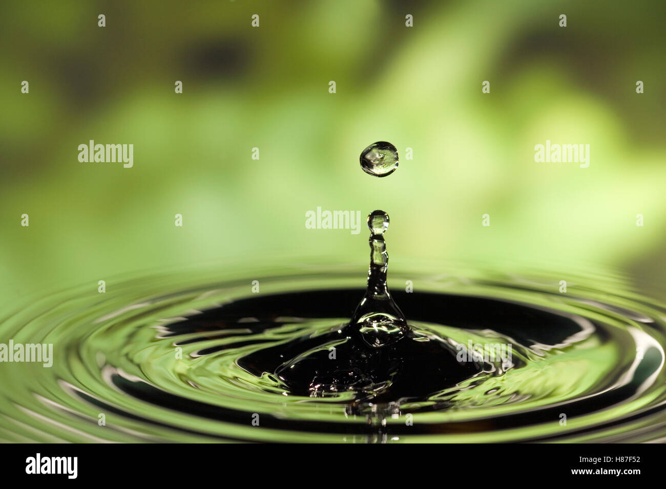 Ripples radiating out from drop of water splashing into calm pool Stock ...