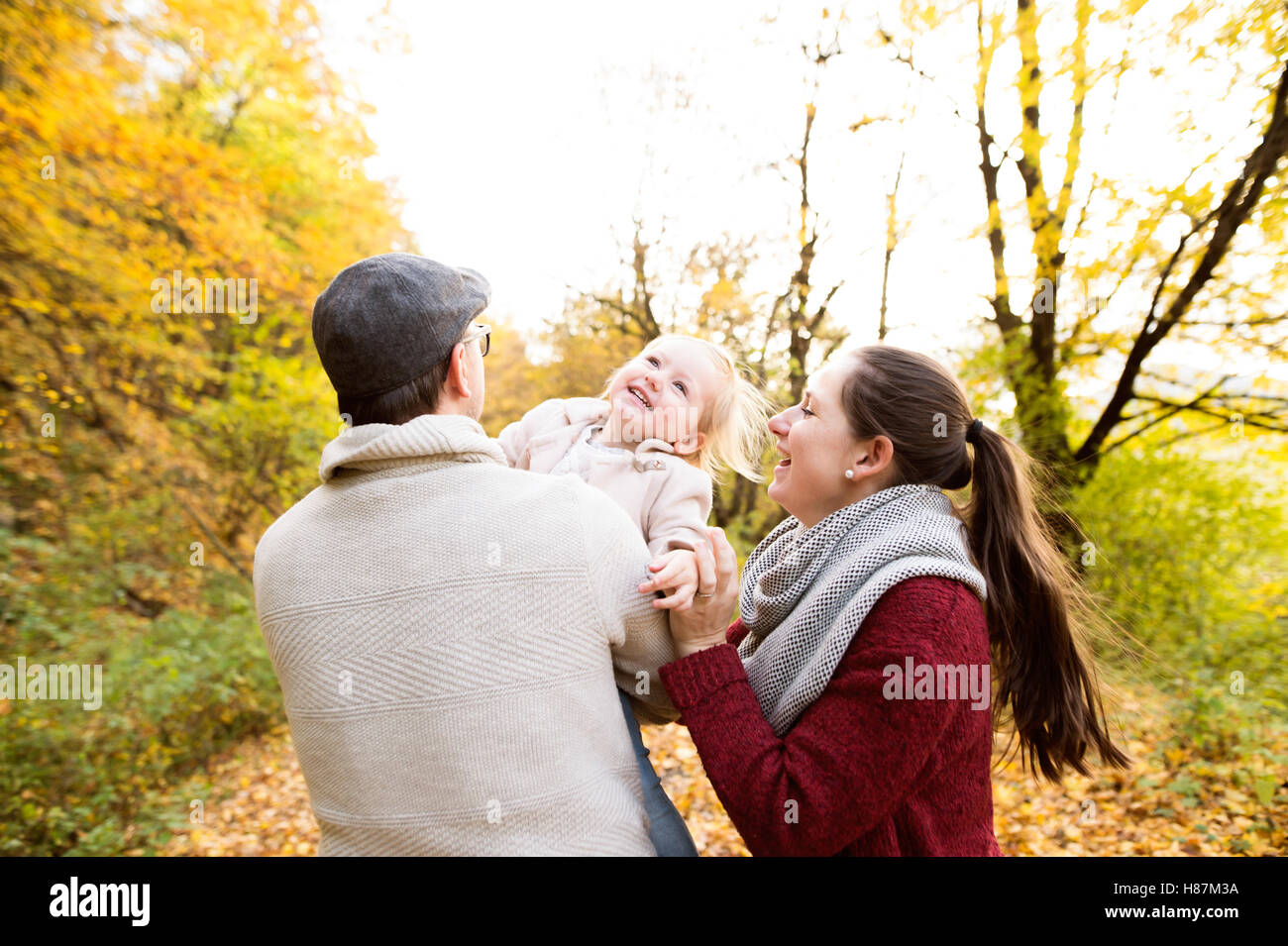 Beautiful young family on a walk in autumn forest Stock Photo - Alamy
