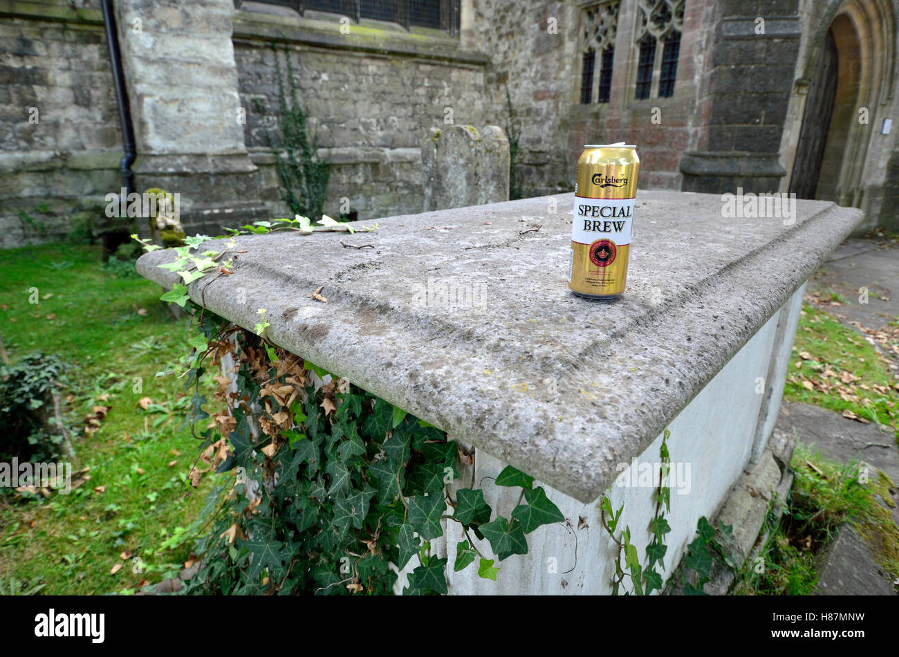 Maidstone, Kent, England, UK. Empty beer can on a tomb in a graveyard Stock Photo