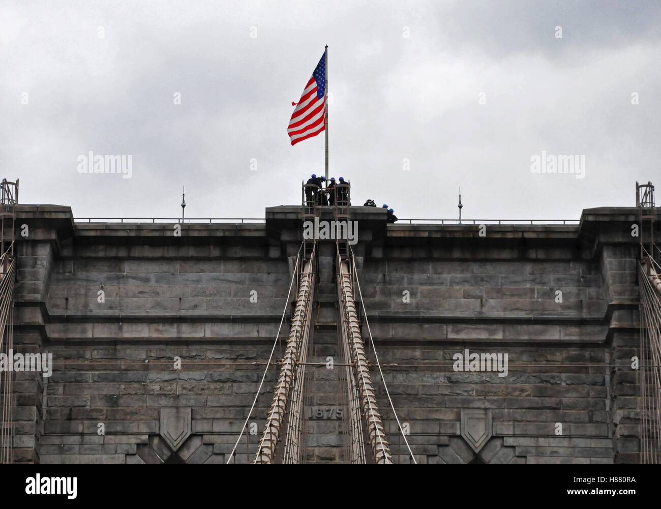 NY, NY. October 28 2016.  City workers fixing the US flag on top of the Brooklyn Bridge. © Veronica Bruno/Alamy Stock Photo