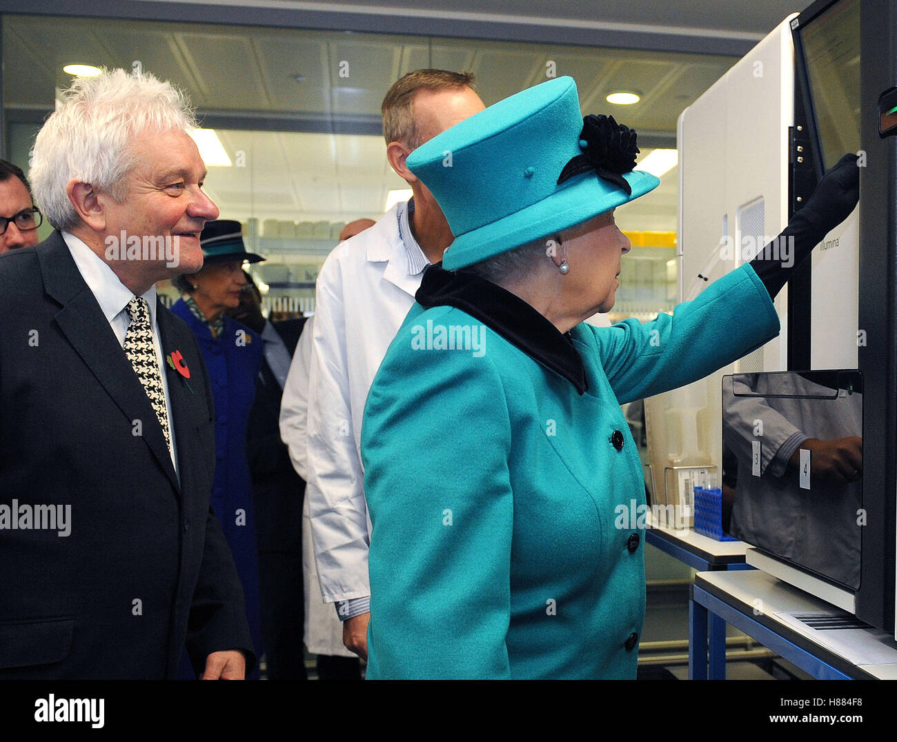 Sir Paul Nurse Director of the Francis Crick Institute watches as Queen Elizabeth II pushes a button to start sequencing Sir Paul's genome during a visit to officially open the Francis Crick Institute in central London. Stock Photo