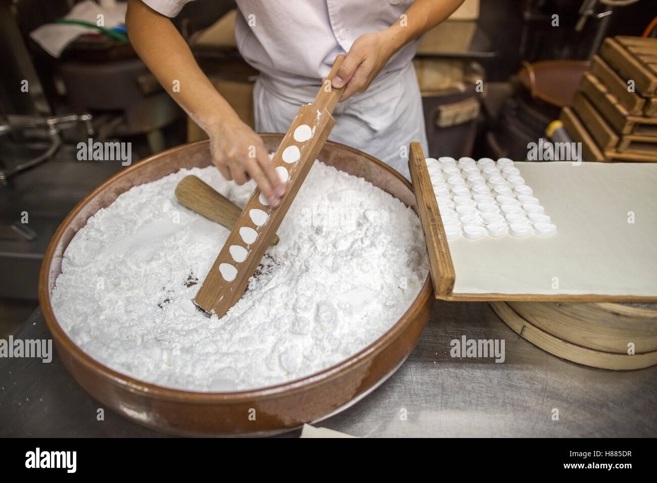 A small artisan producer of wagashi pressing the mixed dough into moulds Stock Photo
