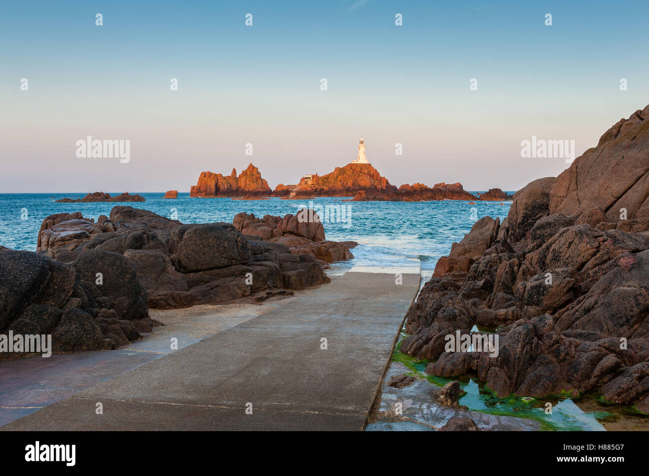 La Corbiere Lighthouse Jersey at sunrise and high tide Stock Photo