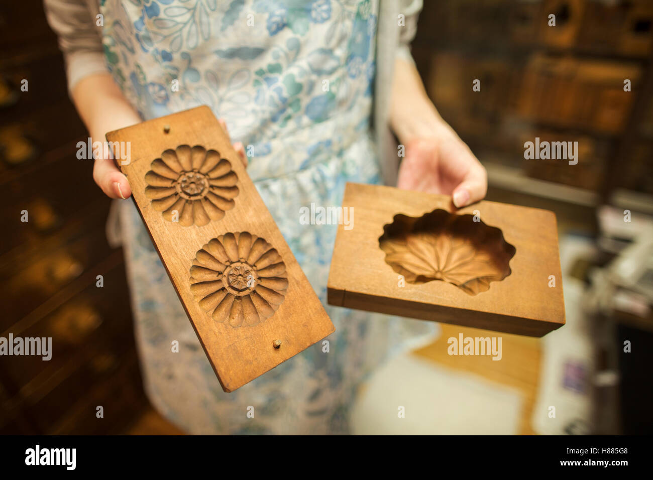 A woman holding shaped wooden moulds used in the production of wagashi sweets. Stock Photo