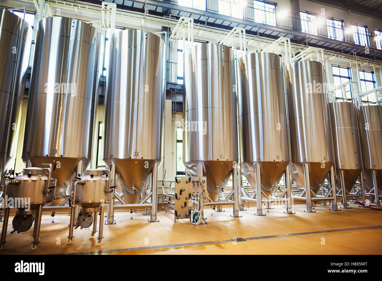 Row of large metal beer tanks in a brewery. Stock Photo