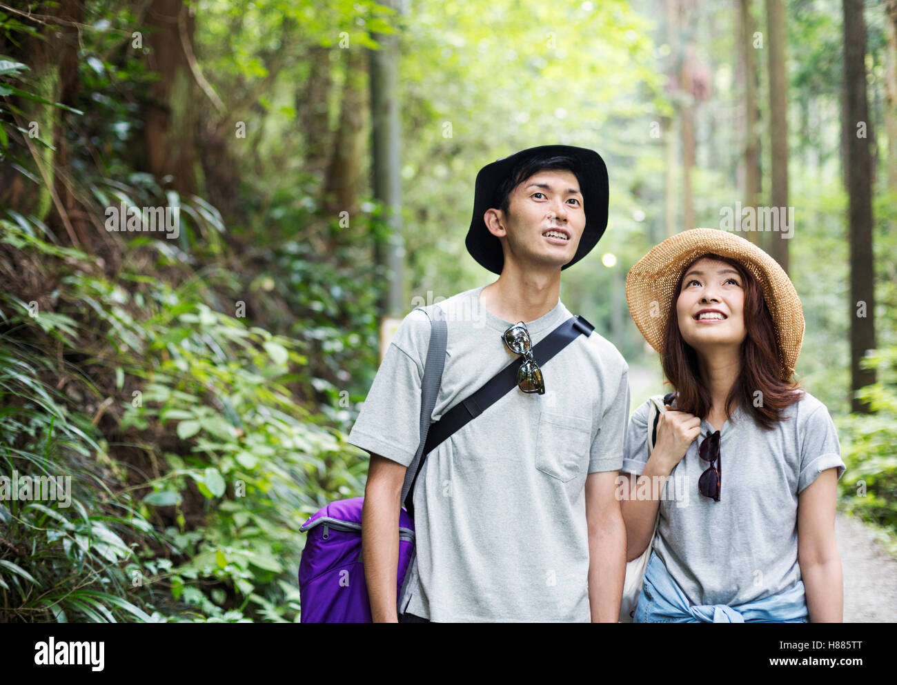 Smiling young woman and man standing in a forest Stock Photo - Alamy