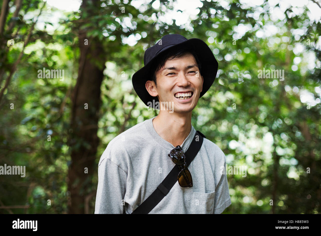 Smiling man wearing a hat standing in a forest Stock Photo - Alamy
