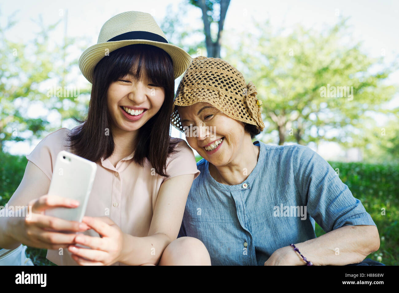 Portrait of a smiling senior woman wearing a crochet hat and a young woman wearing a panama hat. Stock Photo