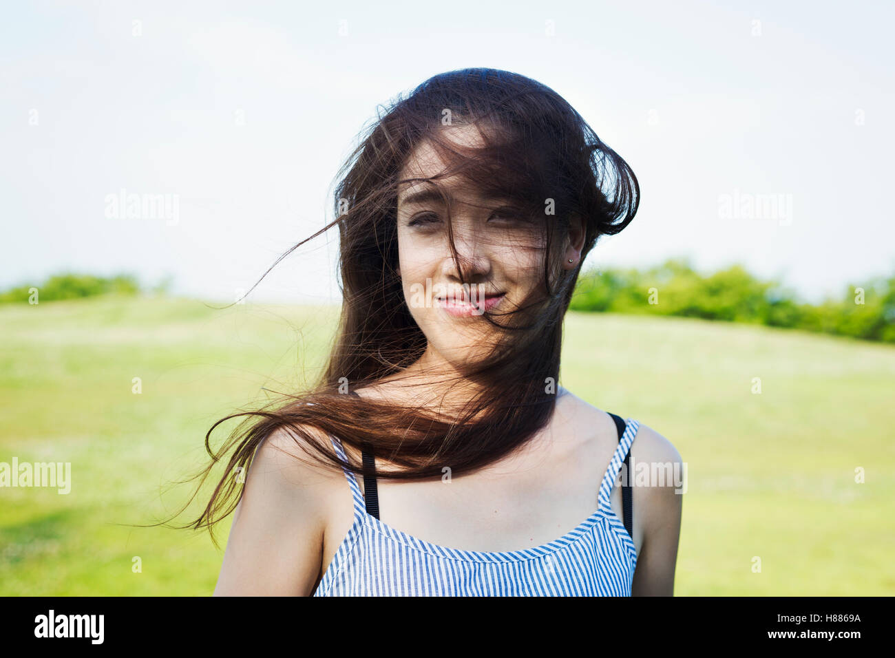 Portrait of a smiling young woman with long brown hair. Stock Photo