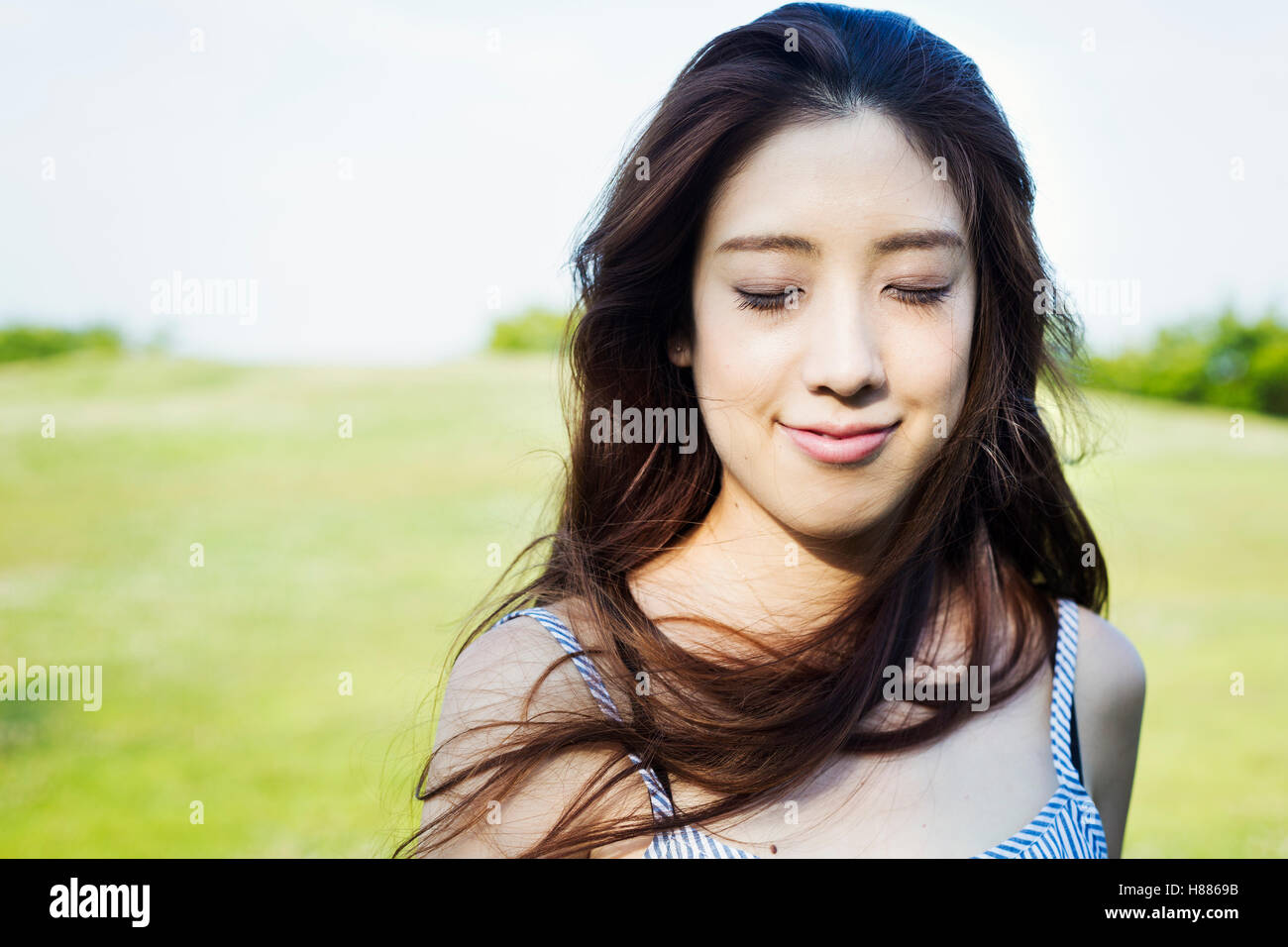 Portrait of a smiling young woman with long brown hair. Stock Photo