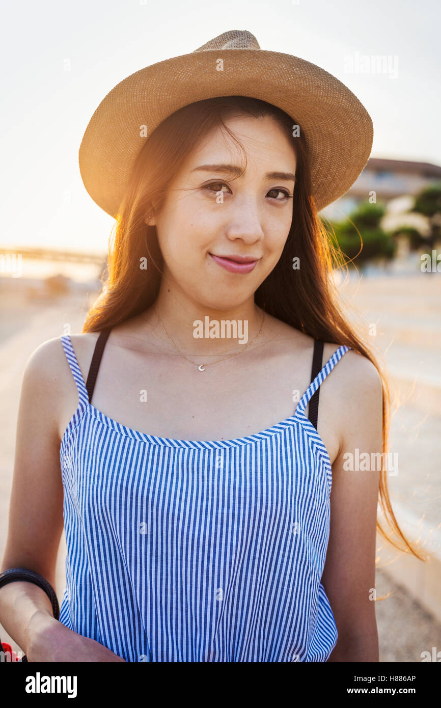 Smiling young woman with long brown hair, wearing Panama hat. Stock Photo
