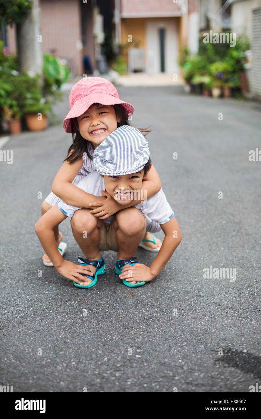 Family home. Two children, a boy and girl playing outdoors. Stock Photo