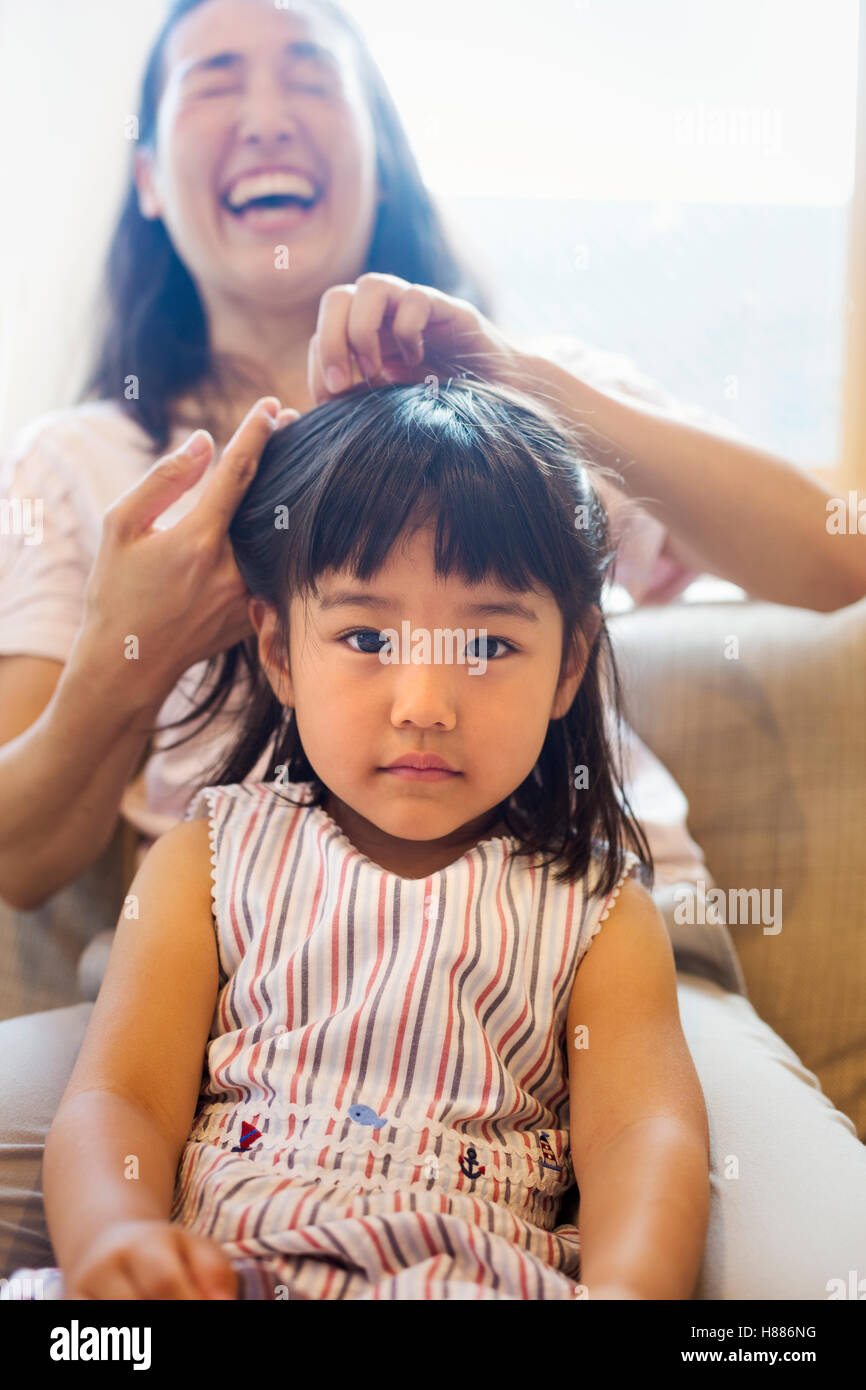Family home. A mother combing her daughter's hair. Stock Photo