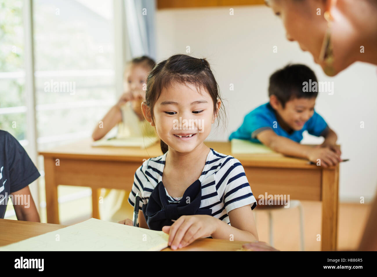A group of children in a school classroom with their teacher. Stock Photo