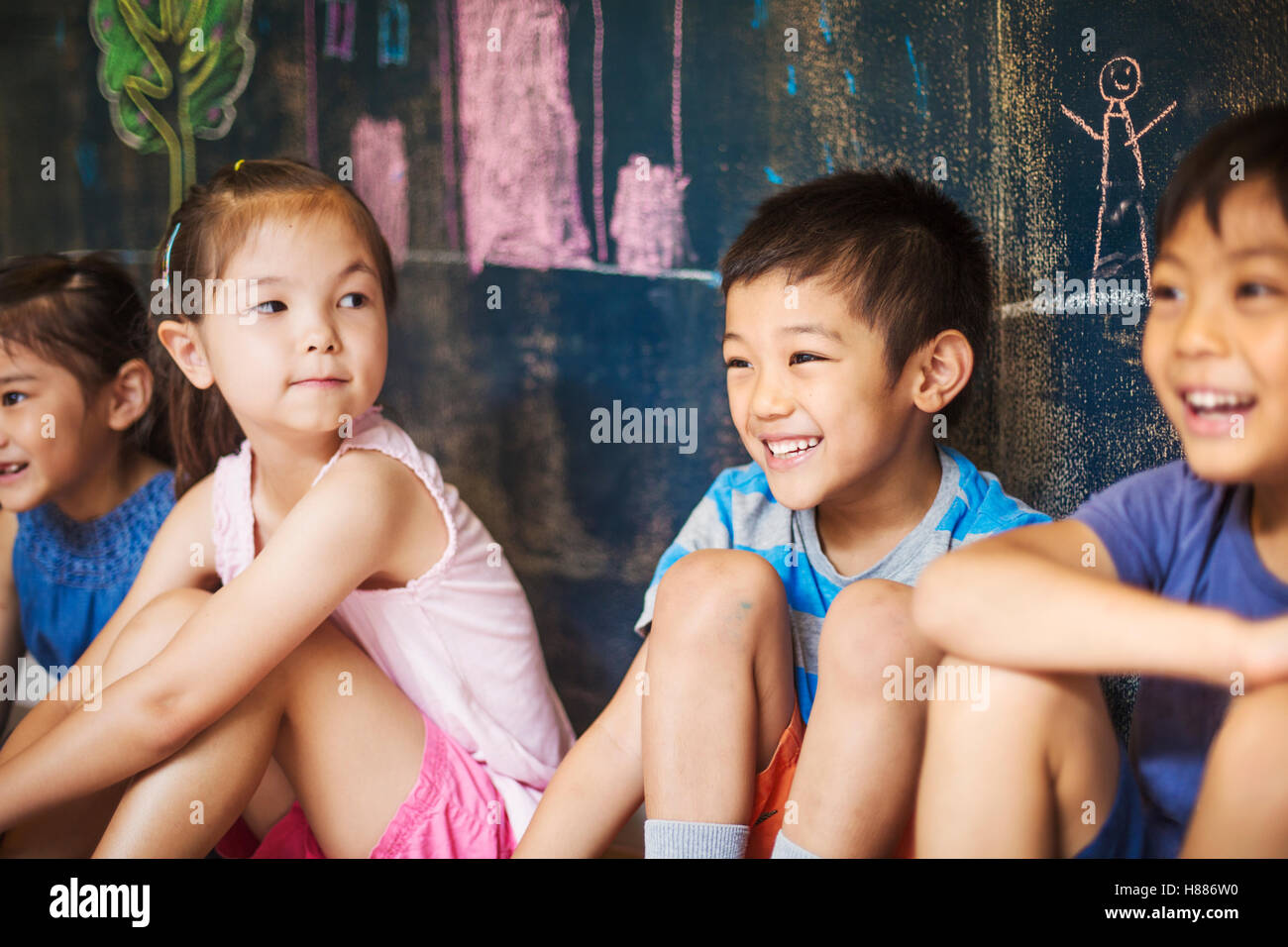 A group of children in school. Boys and girls sitting on the floor. Stock Photo