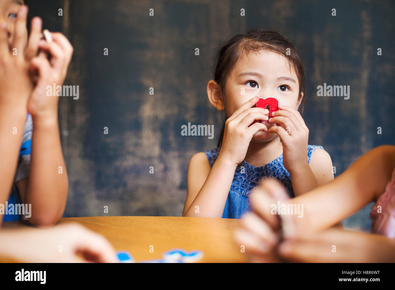 A group of children in school. Two boys and two girls holding up alphabet letters. Stock Photo