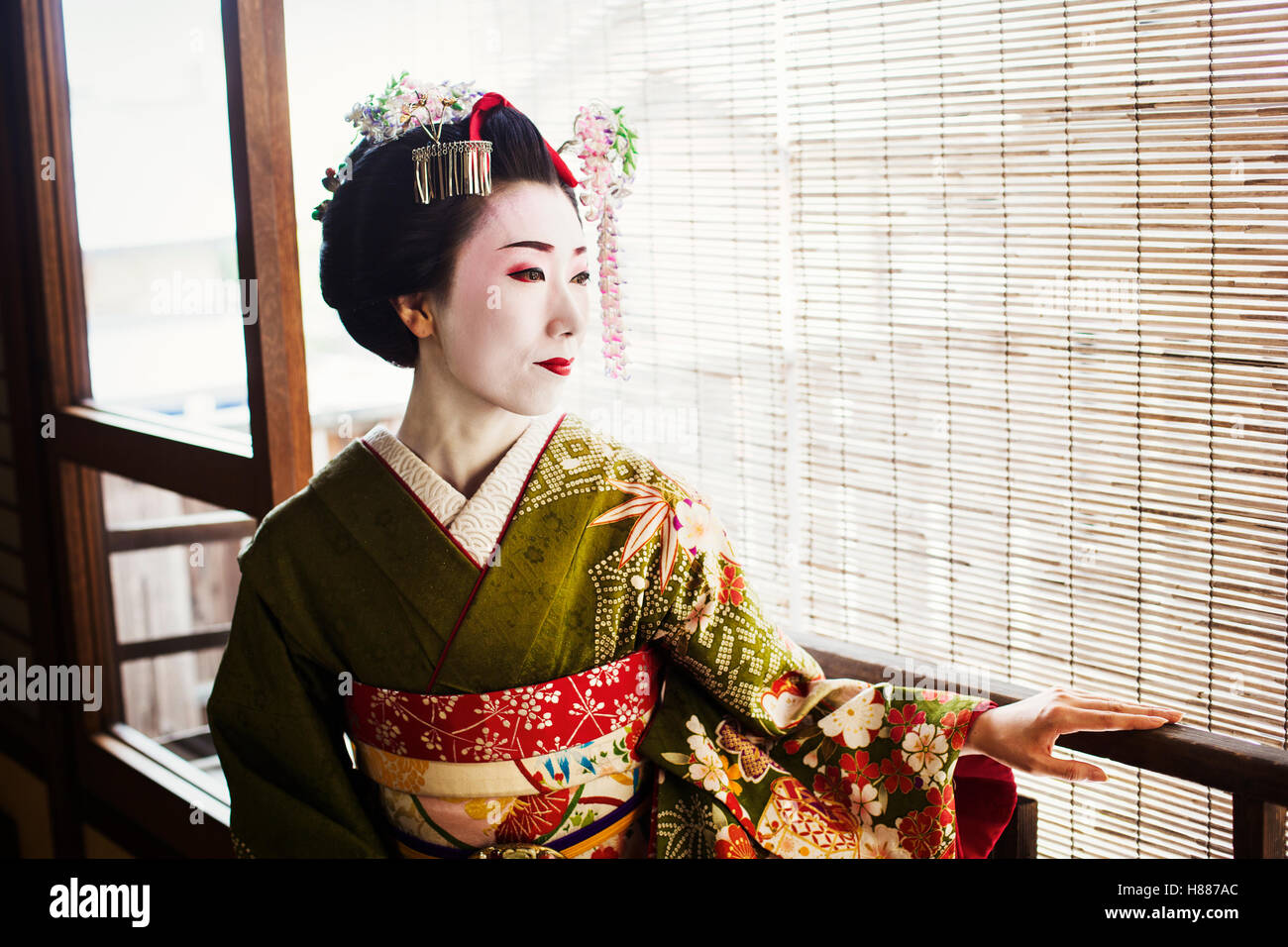 A woman dressed in the traditional geisha style, wearing a kimono and obi Stock Photo