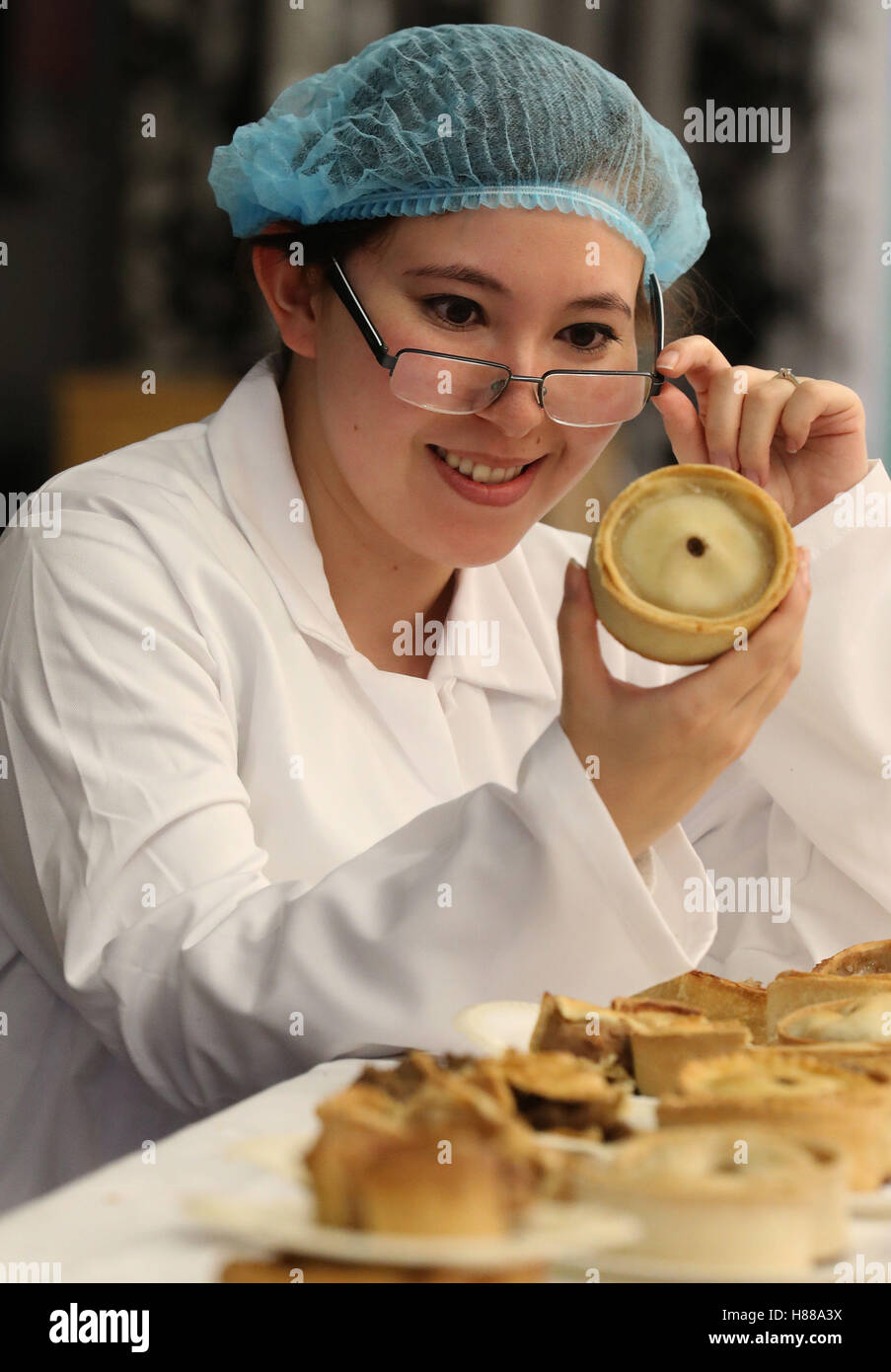 Alexis Craig of the organising team for the World Scotch Pie Championship examines one of the entries at the Carnegie Conference Centre in Dunfermline. Stock Photo